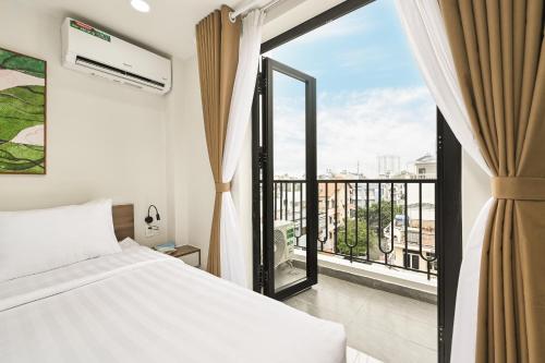 a bedroom with a bed and a balcony at Soi by La Doma Express in Ho Chi Minh City