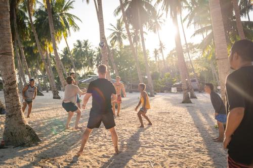 a group of people playing a game of volley ball on the beach at Darocotan Shipwreck Camping in El Nido