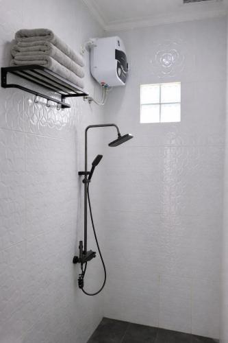 a shower in a bathroom with a white wall at Stone Valley Resort & Beach in Tepus
