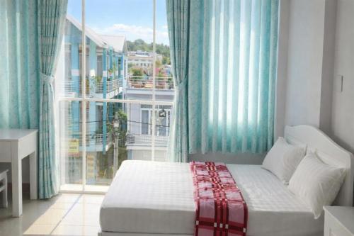 a bedroom with a bed and a large window at Hằng Hoa Hotel Đồng Nai in Dĩ An