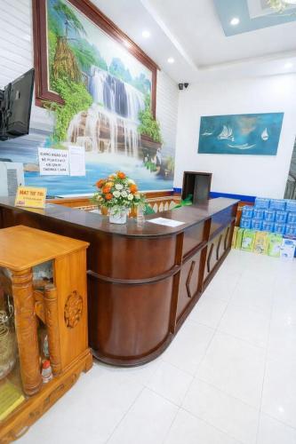a reception desk with a waterfall painting on the wall at Hằng Hoa Hotel Đồng Nai in Dĩ An
