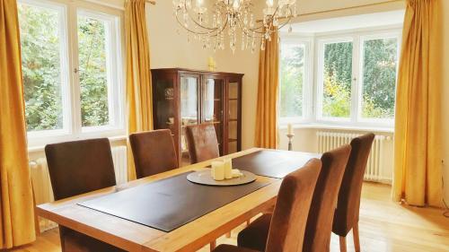 comedor con mesa de madera y sillas en Ferienhaus Sanssouci en Stahnsdorf