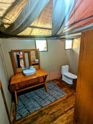 a bathroom with a sink and a mirror and a toilet at Daga Tented Camp in Mikumi