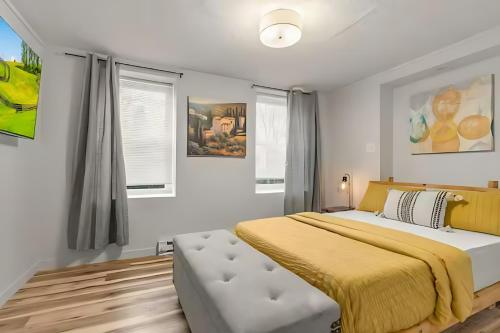 a bedroom with a large bed with a yellow blanket at West Philly Suites in Philadelphia