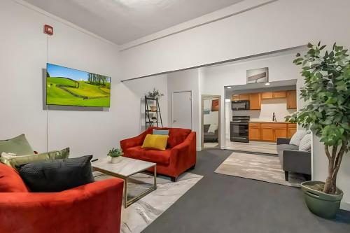 a living room with red furniture and a kitchen at West Philly Suites in Philadelphia