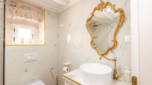 a bathroom with a gold mirror and a sink at Villa Mendula -Orebic by Villas Guide in Orebić