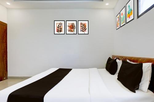 a bedroom with a white bed with black pillows at Hotel O MP Nagar Near Rachna Tower in Bhopal