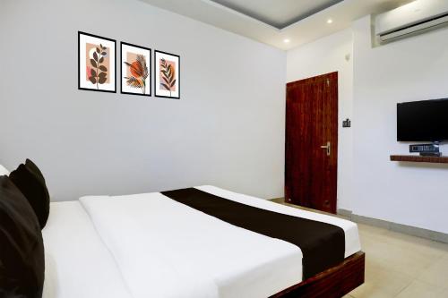 a bedroom with a white bed and a tv at Hotel O MP Nagar Near Rachna Tower in Bhopal