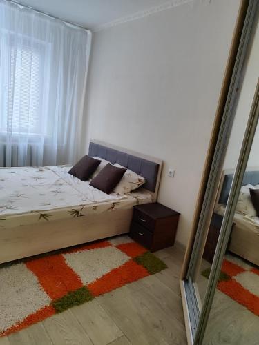 a small bedroom with a bed and a mirror at Квартира в центре Балки, город Тирасполь in Tiraspol