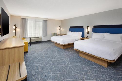 a hotel room with two beds and a desk at Hampton Inn Detroit/Belleville-Airport Area in Belleville