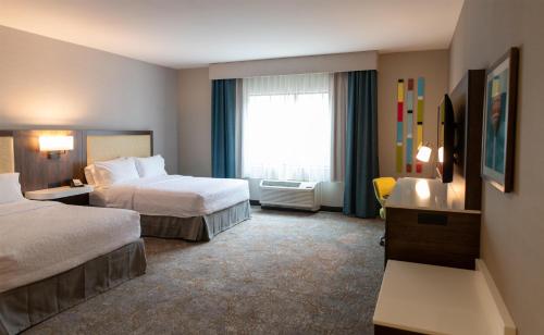 a hotel room with two beds and a window at Hampton Inn Orange City in Orange City