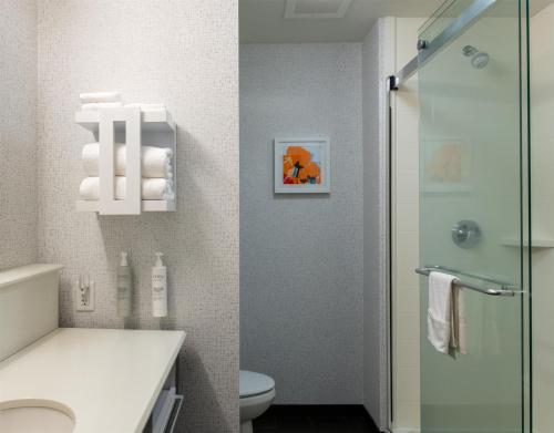 a bathroom with a toilet and a glass shower at Hampton Inn Orange City in Orange City