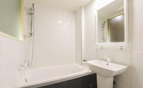 a white bathroom with a sink and a bath tub at 대구 더스테이낭만 태전점 in Daegu