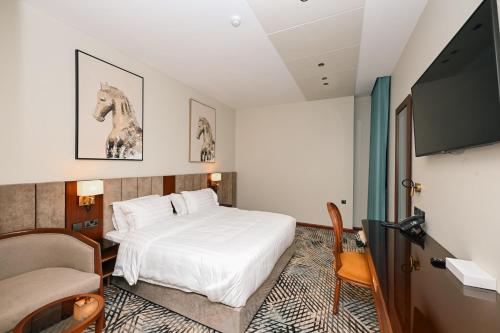 a hotel room with a bed and a flat screen tv at فندق قرى Qira Hotel in Mecca