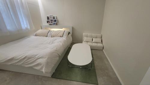 a small bedroom with a bed and a chair at 모던한 스테이 in Samgong