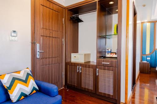 a living room with a blue couch and a cabinet at Sky Charm Hanoi Hotel and Spa in Hanoi