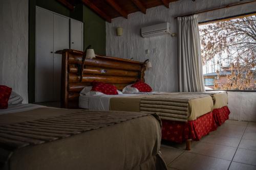 a bedroom with two beds and a large window at Pampas del Sur - Hotel de Campo - Cañuelas in Cañuelas