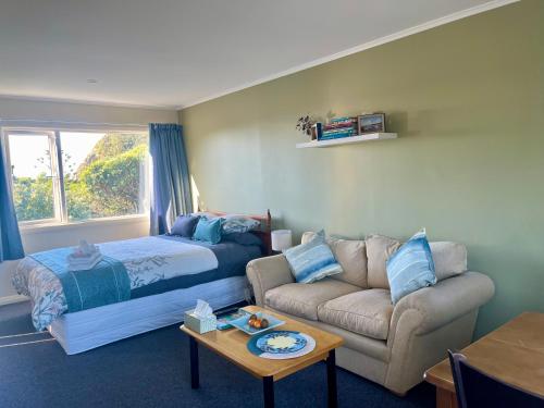 a living room with a bed and a couch at Makara Beach Escape in Wellington