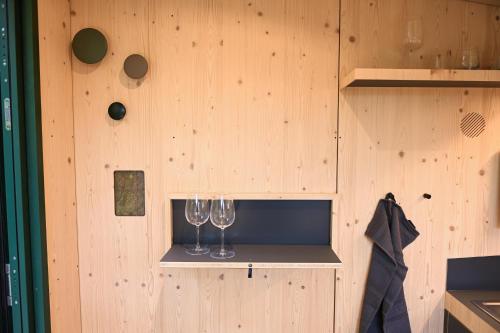 two wine glasses on a shelf in a wooden wall at Green&Tiny Spot Wolfenbüttel Okeraue - Sleep Space 2 in Wolfenbüttel