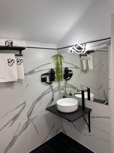a white bathroom with a sink and a counter at Stelele Oltului in Călimăneşti