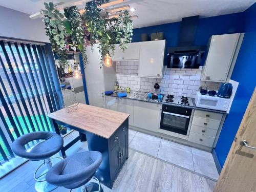 a kitchen with a table and two blue stools at Cozy Southampton Apartment Retreat in Southampton