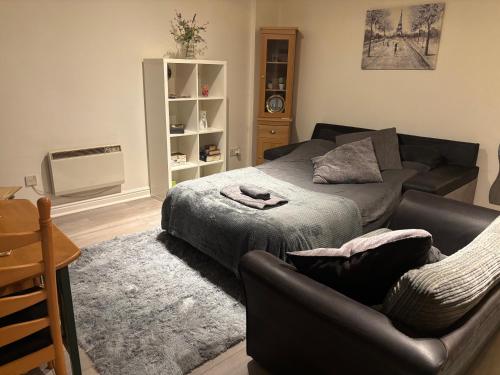 a living room with a bed and a couch at 4 Castle Walk in Stansted Mountfitchet