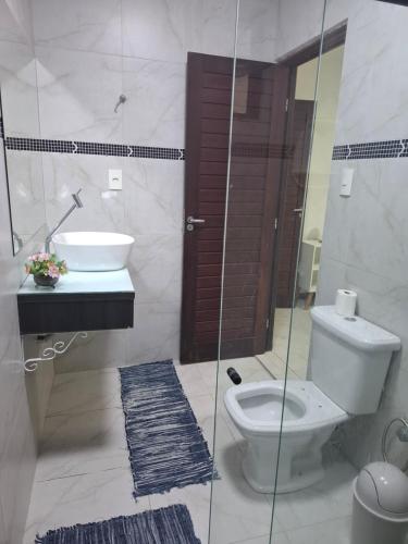 a bathroom with a toilet and a sink at Suíte Tranquila em Ambiente Familiar em Antares in Maceió