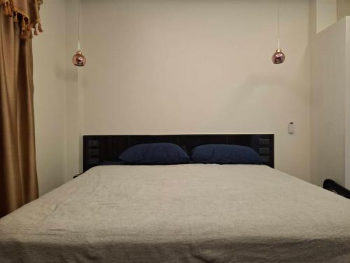 a bedroom with a large bed with blue pillows at Villa Meerblick in Ban Map Khangkhao