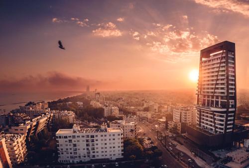 a bird flying over a city at sunset at The Icon Limassol in Limassol