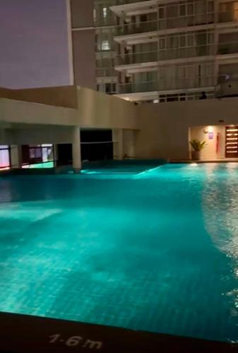 a swimming pool with blue water in a building at The Crescat Suite by Cinnamon Grand in Colombo