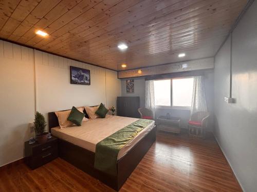 a bedroom with a large bed in a room at Tholangi Homes in Darjeeling