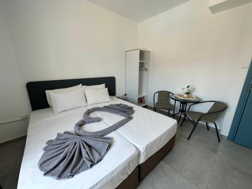 a bedroom with a bed with a blanket on it at Golden Sun Rooms - Adults Only in Ayia Napa