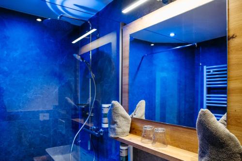 a bathroom with blue walls and a mirror at B&B Gästehaus Alpenblick in Lermoos