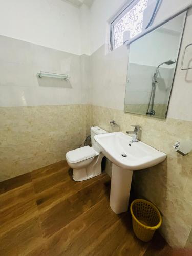 a bathroom with a white sink and a toilet at Blissbarn Inn Ella in Ella