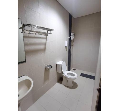 a bathroom with a toilet and a sink at Hotel O Pavilion Inn Hotel in Lumut