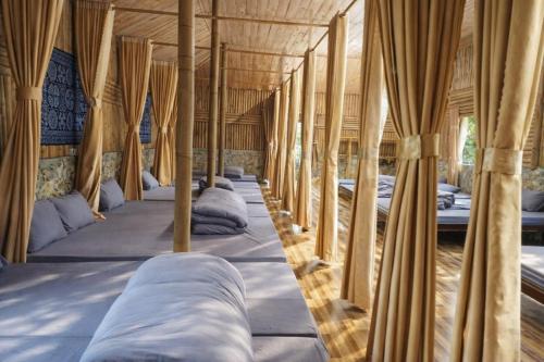 a row of beds in a room with curtains at Y Sao Homestay in Hòa Bình