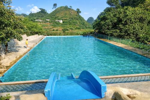 a large pool with a slide in the water at Y Sao Homestay in Hòa Bình