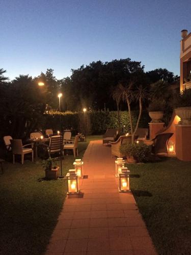 a pathway with lights in a yard at night at Hotel 1908 in Forte dei Marmi
