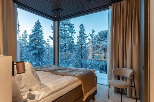 a bedroom with a bed and a large window at Inai Haven in Ivalo