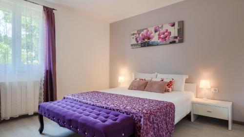 a bedroom with a large bed with a purple blanket at Villa Melnica by Villas Guide in Barban