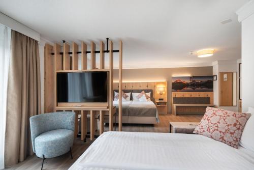 a hotel room with a bed and a television at Hotel Grindelwalderhof in Grindelwald