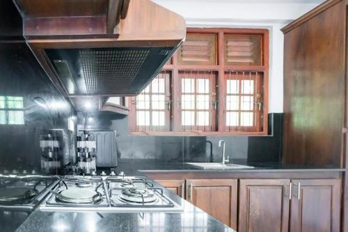 a kitchen with a stove and a counter top at Villa Amora Hikkaduwa in Hikkaduwa