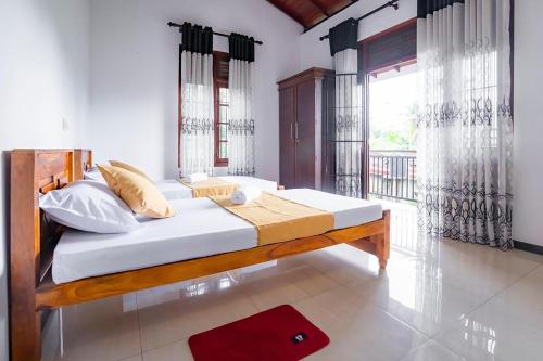 a bedroom with a bed and a large window at Villa Amora Hikkaduwa in Hikkaduwa
