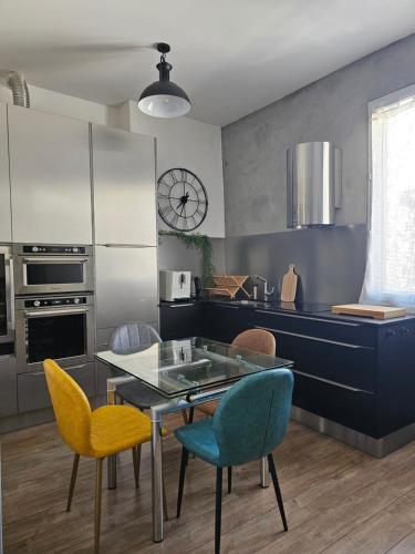 kuchnia ze szklanym stołem i żółtymi krzesłami w obiekcie Cosy city w Montpellier