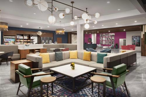 a lobby with a couch and tables and a bar at Home2 Suites By Hilton Huntsville Village Of Providence in Huntsville