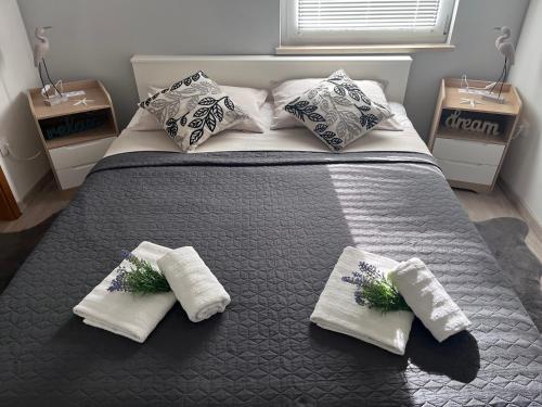a bedroom with a large bed with three pillows at Apartman Dani - Sutivan in Sutivan