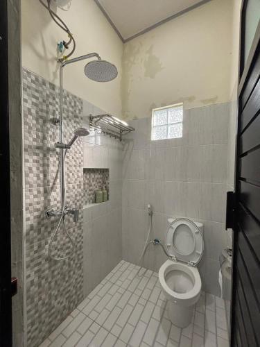 a bathroom with a shower and a toilet in it at Heiwana House #1 in Beran-kidul