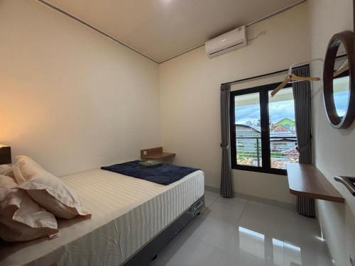 a bedroom with a bed and a large window at Heiwana House #1 in Beran-kidul