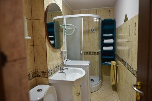 a bathroom with a sink and a toilet and a mirror at Glow Sahara in Focşani