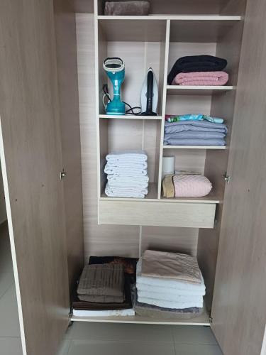 a cupboard with towels and a blender in it at Pousada Mineiro in Curitiba